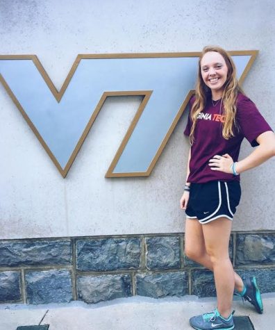 Senior Jenna Beattie poses in front of VT sign after commiting to swim there in the fall.