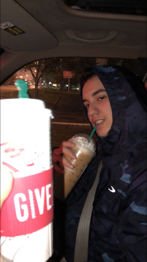 Relaxing, Zach is enjoying some Starbucks in a car.