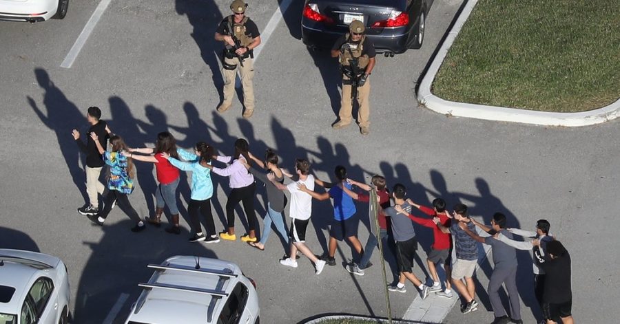 Students walk outside the school with hands on eachothers shoulders showing they are not a threat. The Millitary and police evacuated the building as quick as possible. 
