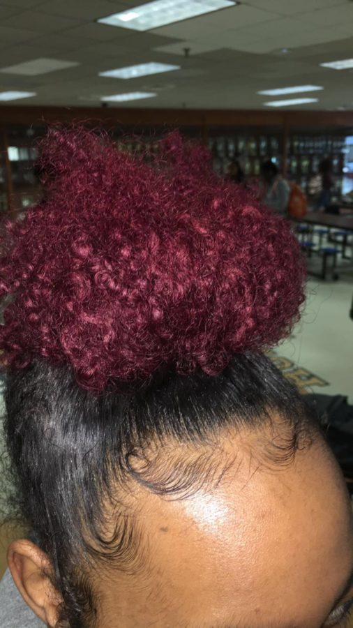 Her bun is dyed red while the bottom half is black and you can see her edges laid.