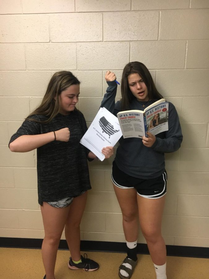 Juniors Claire Kennis and Lauren Wrann angrily study for their AP United States History exam. Lauren is using her packet given by her teacher to study and Claire is using a book she borrowed from a friend to study.