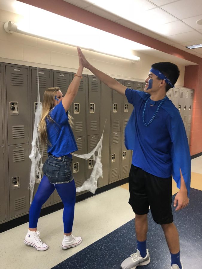 Drew Ramos high fives his friend Colby as he finds her in the hall.