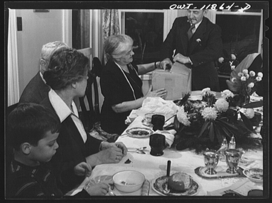 Families join together to eat dinner on Thanksgiving.