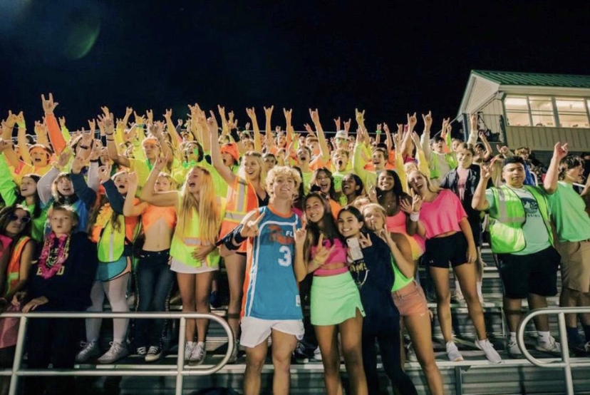 Neon+themed+football+games+are+so+much+fun+because+our+student+section+is+glowing%2C+literally.+Here+you+see+everyone+doing+horns+up%21