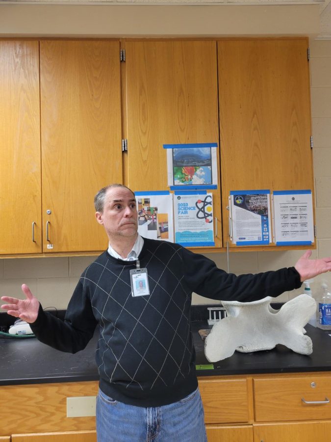 Mr. Roesch, lover of bulldogs and Virginia Tech posing which a massive spine bone in his classroom!