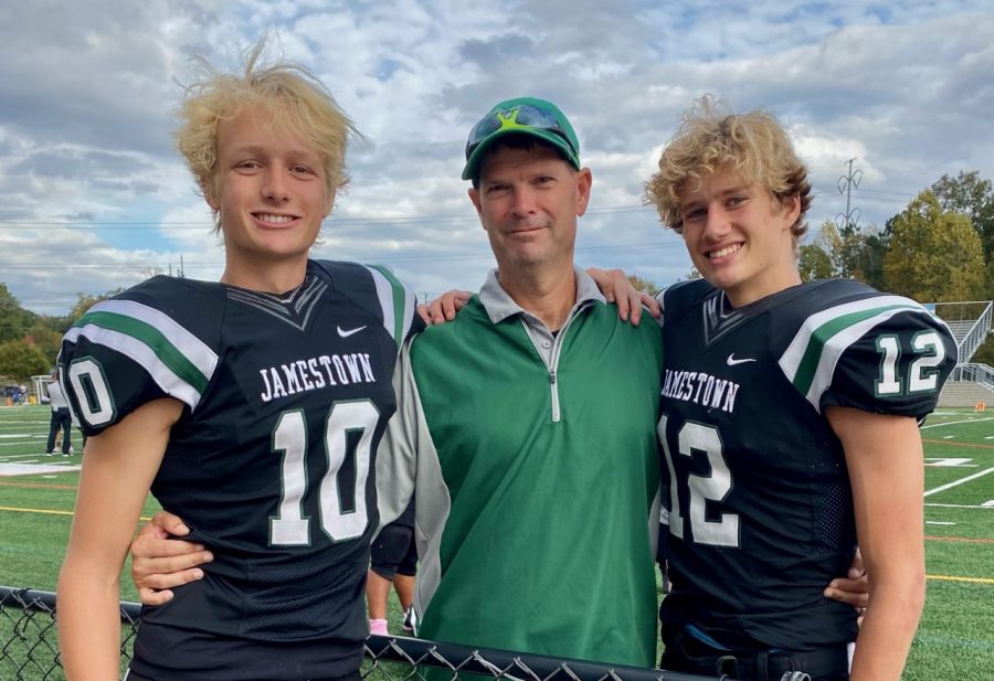 Coach Smith stands next to the Oleksy Brothers as their last game of the 2021 Football season.