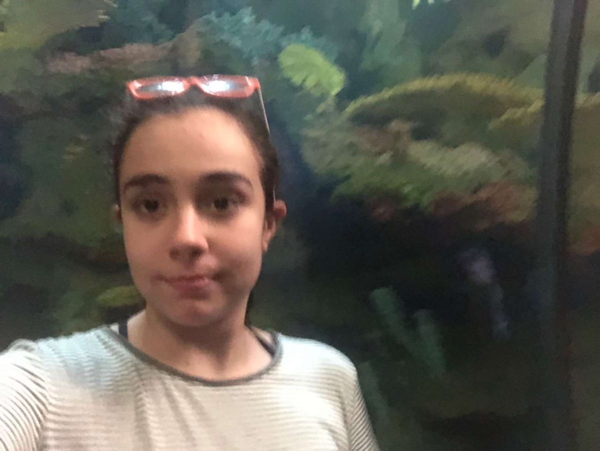 A young val poses with her favorite fish at the aquarium.