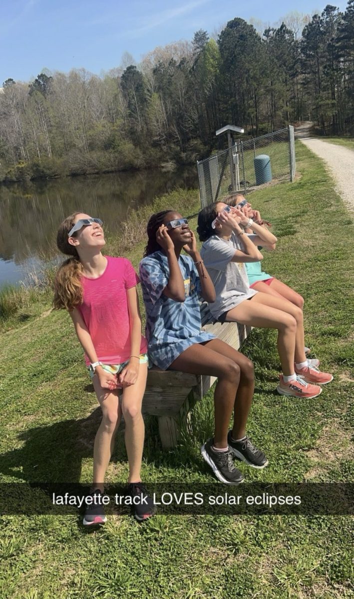 Taking a short break from the run, Lafayette Girls distance team watches the solar eclipse. (Anouk Mapp, Wendy Ouedraogo, Valentina Martiniello, Olivia Simone). 