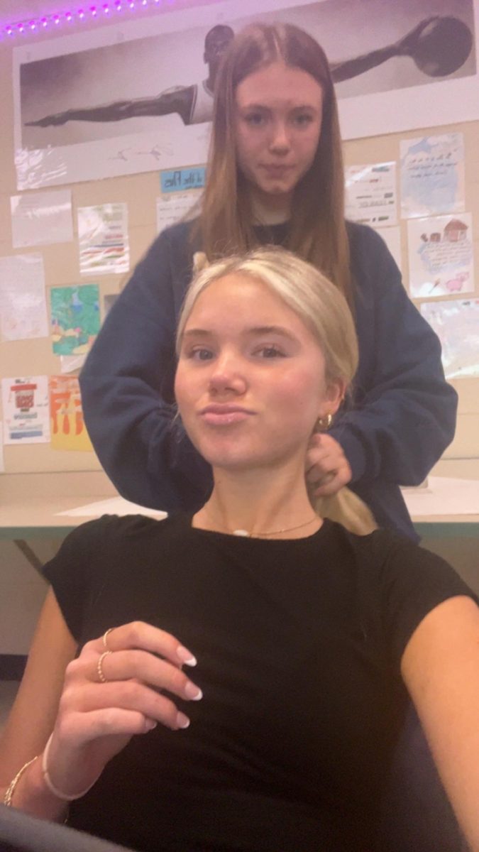 Mandi and Lauren messing around and doing hair in their journalism class after completing their work. 