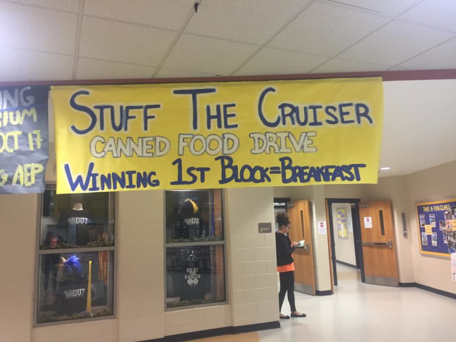 "Stuff The Cruiser" poster hangs above the upper  commons to remind students to help our community by bringing cans.