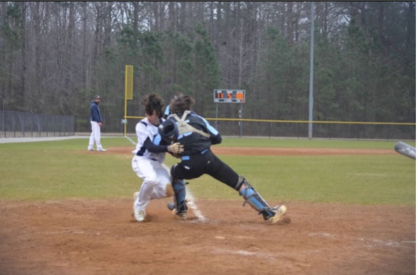 Lafayette high school Junior, Thomas McLaughlin collides with Warhill catcher Junior, Riley Motley at a close play at the plate.