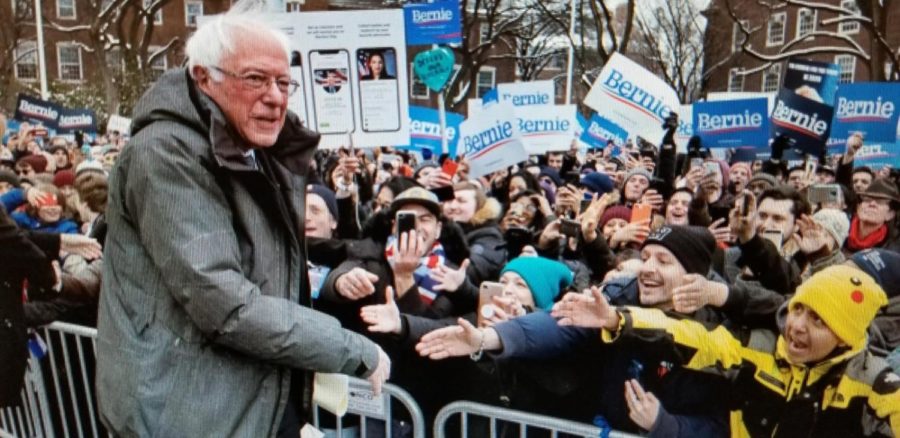 Bernie shaking hands with his supporter at a rally