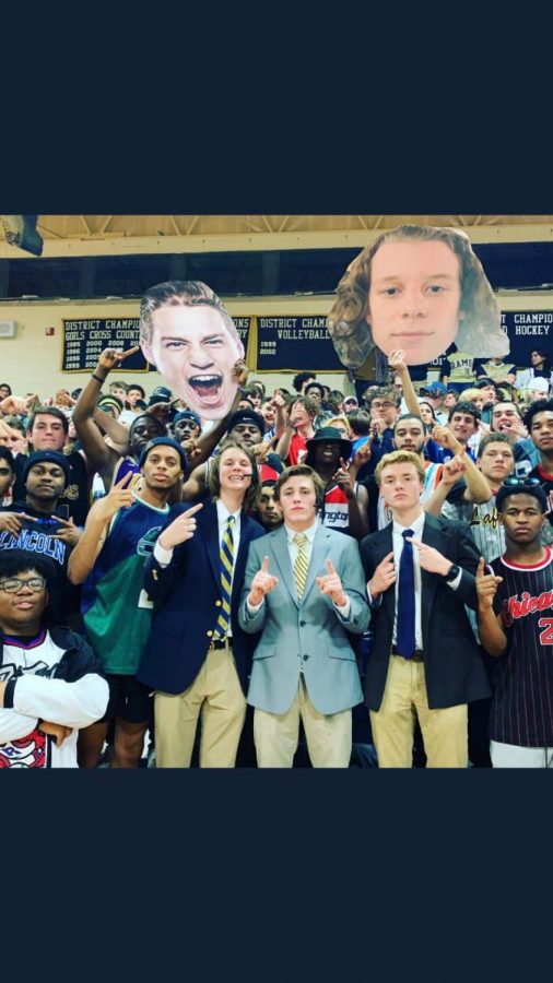 Showing school spirit by supporting the team with some of the players pictures on fatheads. Three of our students went full out by dressing up in suits, wearing headsets, and had a fake table made out of carboard acting like sports commentators from ESPN. The rest of the student section finished the look with all of them wearing sports jerseys.