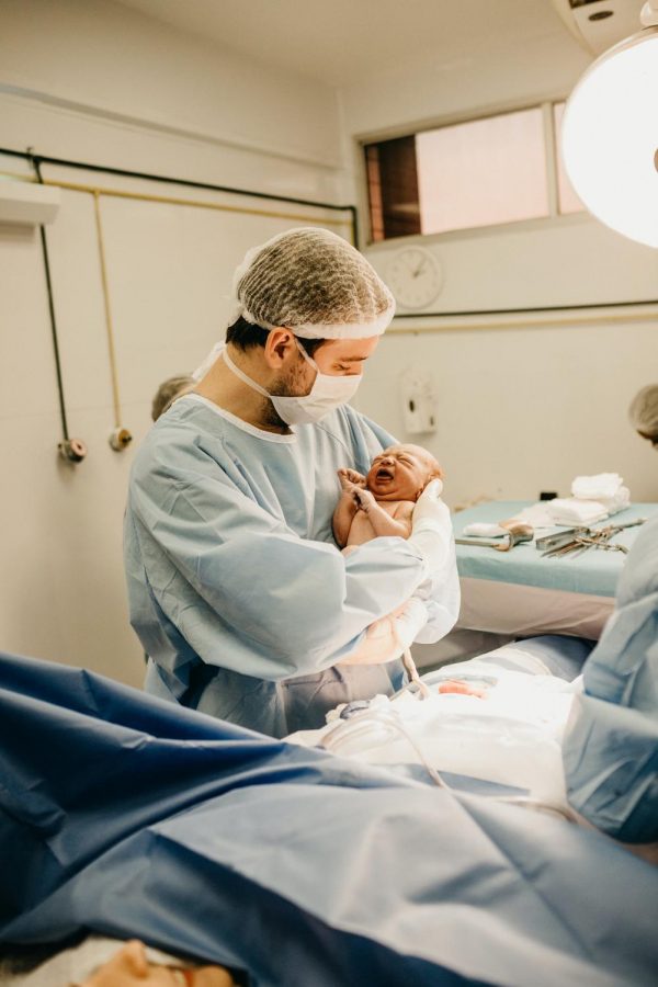 A doctor right after delivering a newborn. One of the many things that can't just pause due to the virus.