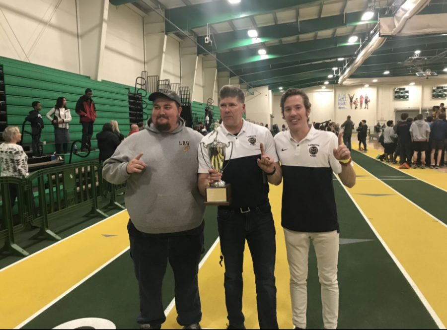 Coaches holding the states trophy that the team won last year at regionals.