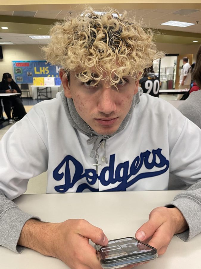 Lunch is a great time to socialize with friends, and maybe make some new ones. Roman Ayala, grade 11, has finished eating and scrolls on his phone. 