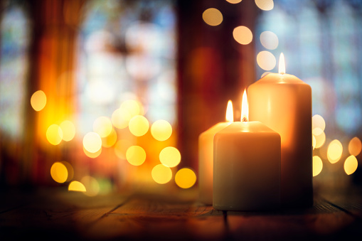 Candles burning in a church background