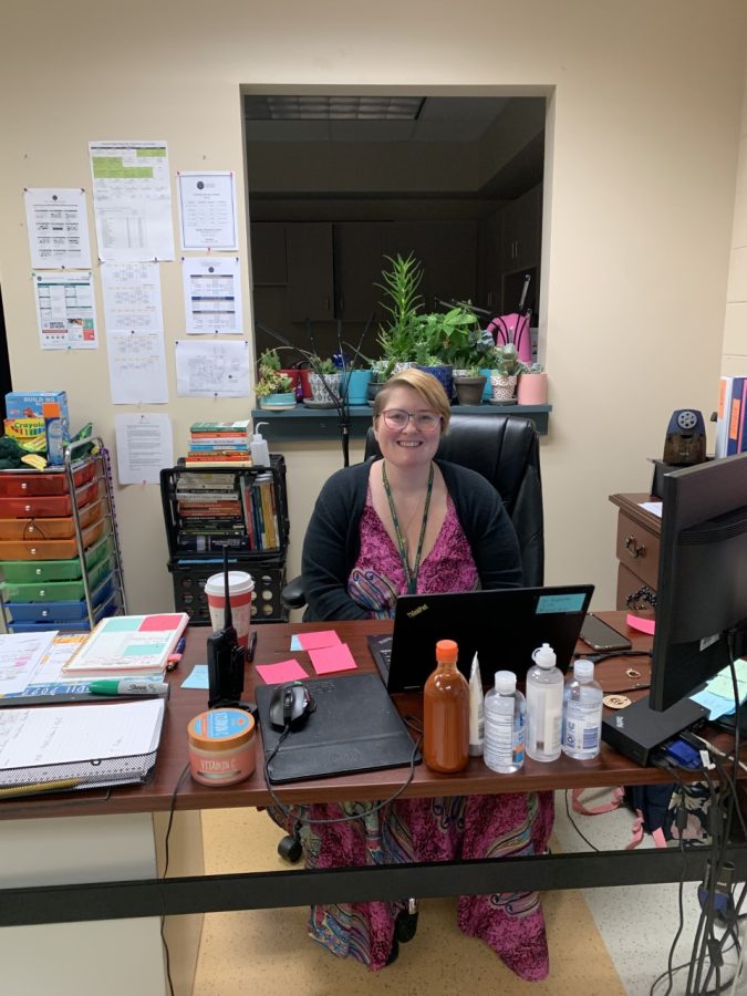 Ms. Rodenbo seated in her colorful classroom