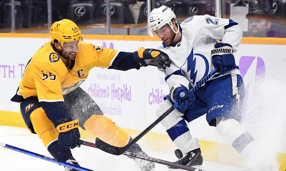 Roman Josi(left) covering Brayden Point(right) after he poked the puck out near the boards.