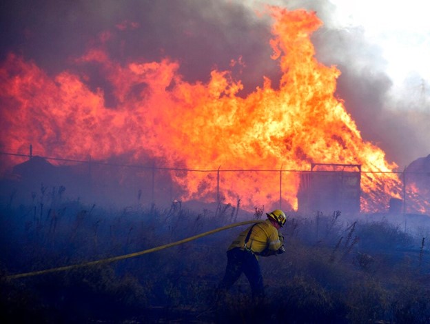 Rolling smoke roars over the lands of Los Angeles. Firefighters work hard to contain the wildfires. 